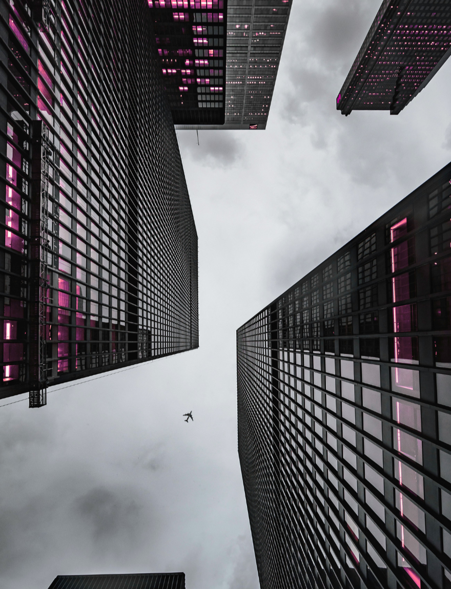 Towering buildings viewed from below against a cloudy sky